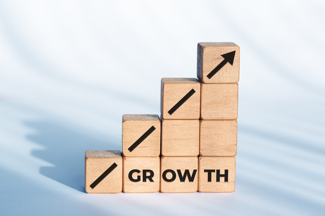 Wooden blocks stacked as a rising bar chart symbolizing business growth and financial performance.